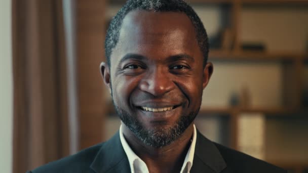 Close-up mannelijk business portret glimlachend tevreden volwassen Afrikaan amerikaanse man die binnen staat te kijken naar camera gelukkig vertrouwen succesvolle zakenman ondernemer tevreden klant poseren in kantoor - Video