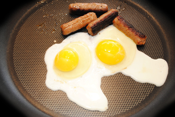 2 つの卵とフライパンでソーセージをフライパン - 写真・画像