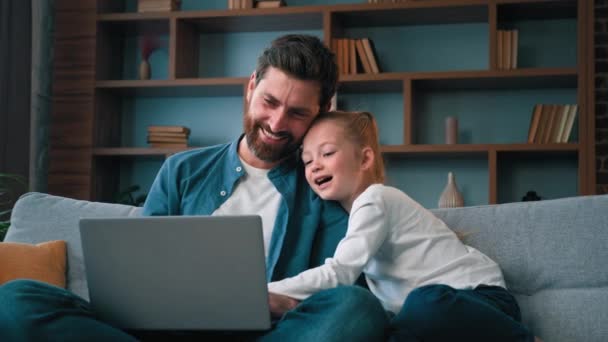 Isä mies ja pieni kaunis tyttö lapsi lapsi katsella video verkossa kannettava tietokone ihana valkoihoinen perhe nauraa viettää rauhallista aikaa yhdessä nauttia viikonloppuna kotona käyttää modernia tekniikkaa tehdä internet-ostoksia - Materiaali, video