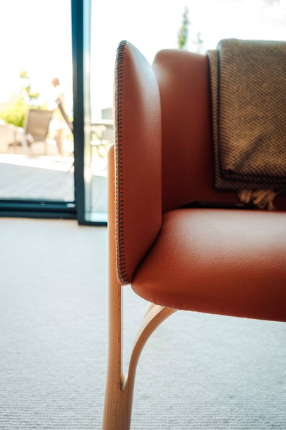 A vertical shot of a leather chair with a throw blanket draped on the back - interior inspiration - Valokuva, kuva