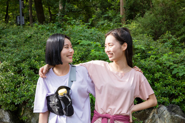 korean young women hiking and plogging_smiling face to face - Foto, afbeelding