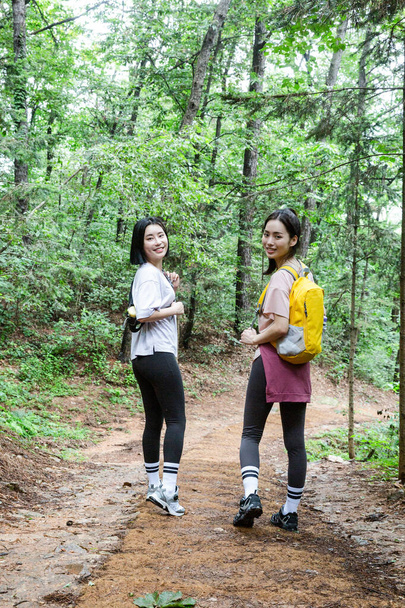 mujeres jóvenes coreanas senderismo y plogging _ trekking montaña - Foto, imagen