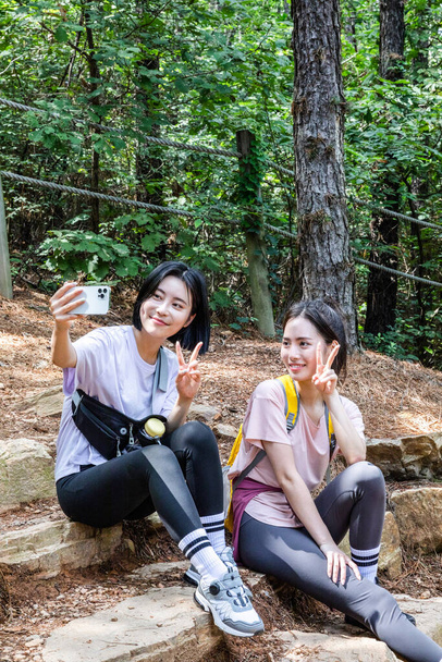 korean young women hiking and plogging_taking photo - Photo, Image