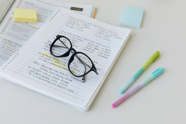 studying at home, study desk setup_handwriting notes and writing instruments glasses - Zdjęcie, obraz