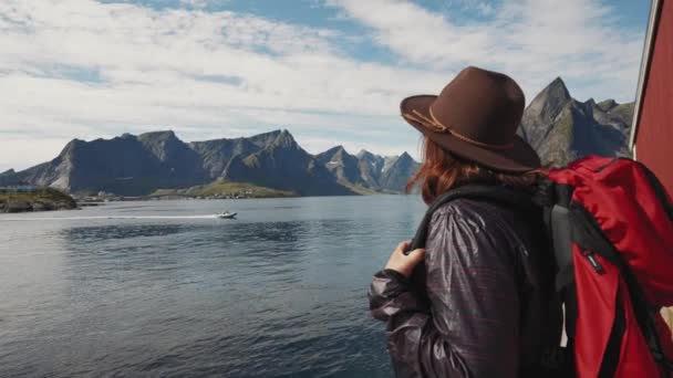 Reiseleiterin mit Rucksack blickt auf die schöne Aussicht auf die Lofoten. - Filmmaterial, Video