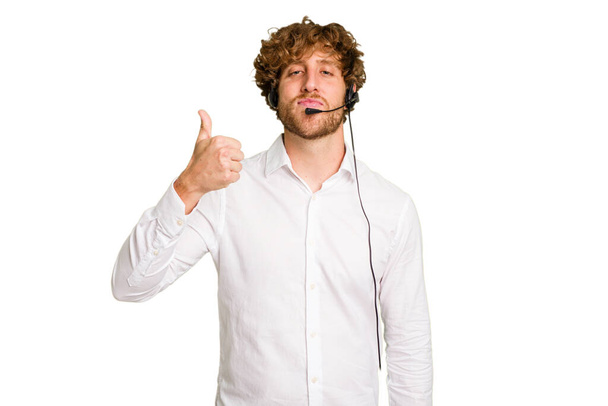 Telemarketer man working with a headset isolated on green chroma background smiling and raising thumb up - Φωτογραφία, εικόνα
