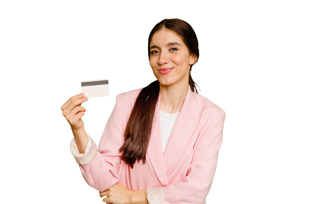Business caucasian woman holding a credit card isolated laughing and having fun. - Fotó, kép