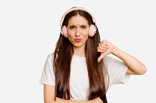 Young caucasian woman wearing headphones isolated showing a dislike gesture, thumbs down. Disagreement concept. - Fotografie, Obrázek