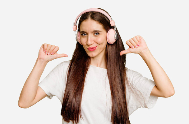 Young caucasian woman wearing headphones isolated feels proud and self confident, example to follow. - Foto, Bild