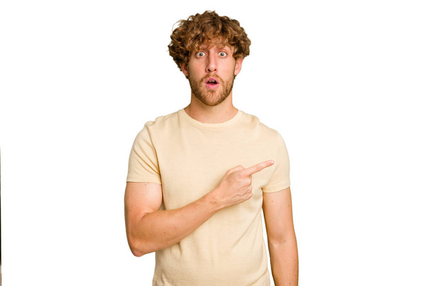 Young caucasian man isolated on green chroma background pointing to the side - Photo, Image