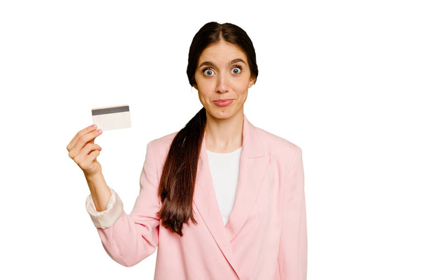 Biznes kaukaski kobieta trzyma karty kredytowej pojedyncze ramiona ramiona i otwarte oczy mylić. - Zdjęcie, obraz