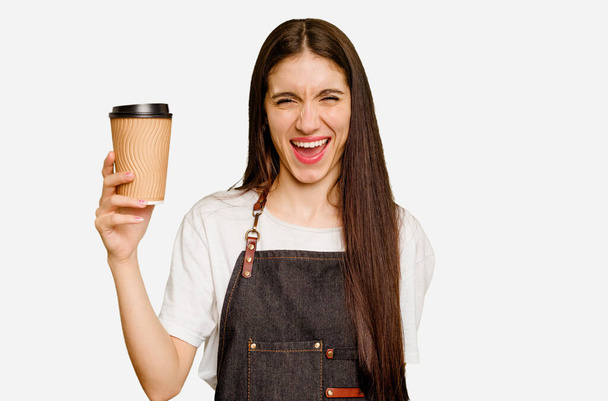 Mladá barista žena drží odnést kávu izolované křičí velmi rozzlobený a agresivní. - Fotografie, Obrázek