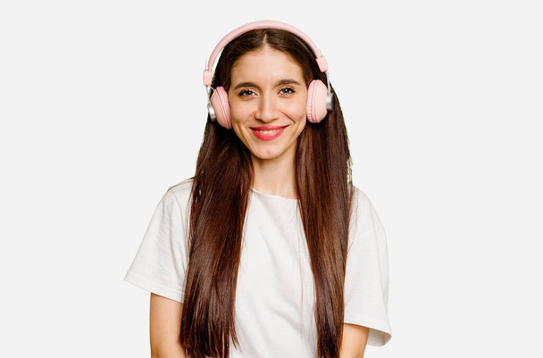 Young caucasian woman wearing headphones isolated happy, smiling and cheerful. - Фото, изображение