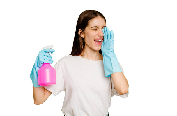 Young cleaner woman isolated shouting and holding palm near opened mouth. - Photo, Image