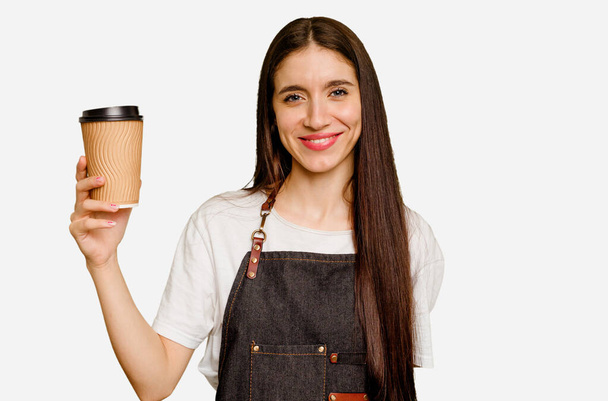 Mladá barista žena drží odnést kávu izolované šťastný, usmívající se a veselý. - Fotografie, Obrázek