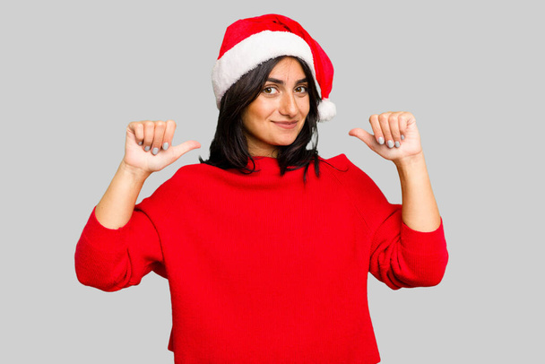 Молода індійська жінка, яка святкує Різдво, одягнута в капелюх у Санті, почувається гордою і впевненою в собі.. - Фото, зображення