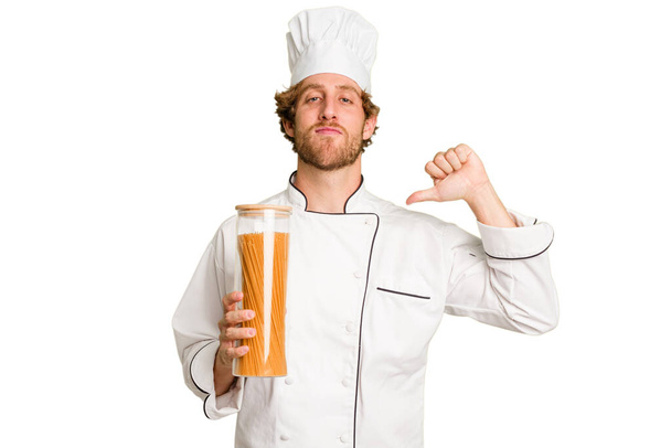 Jonge kok man geïsoleerd op witte achtergrond voelt trots en zelfvertrouwen, voorbeeld te volgen. - Foto, afbeelding