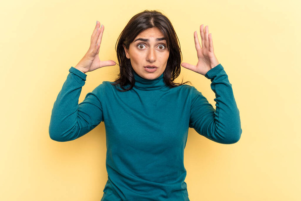 Young Indian woman isolated on yellow background celebrating a victory or success, he is surprised and shocked. - Foto, Imagem