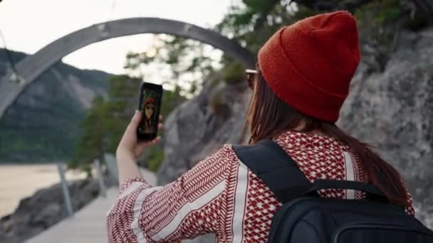 Egy gyönyörű turista lány a folyóparti túrán szelfit készít, lefényképezi magát telefonon.. - Felvétel, videó