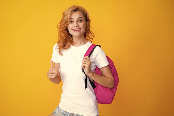 Surprised fun teen student girl with backpack on pastel yellow color background. Education in university college concept - Photo, Image