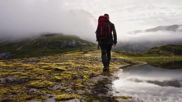 Moeilijk klimmende mannelijke ontdekkingsreiziger in de mistige bergen. Geen uitzicht vanaf de bergwand maar mist in plaats daarvan. - Video
