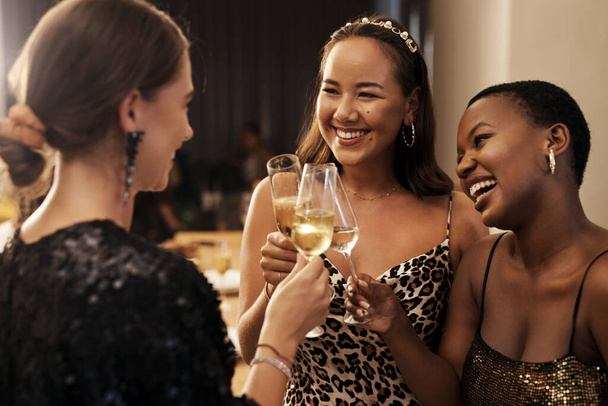 Its always a good time when were together. a diverse group of friends standing together and toasting with champagne during a New Years dinner party - 写真・画像