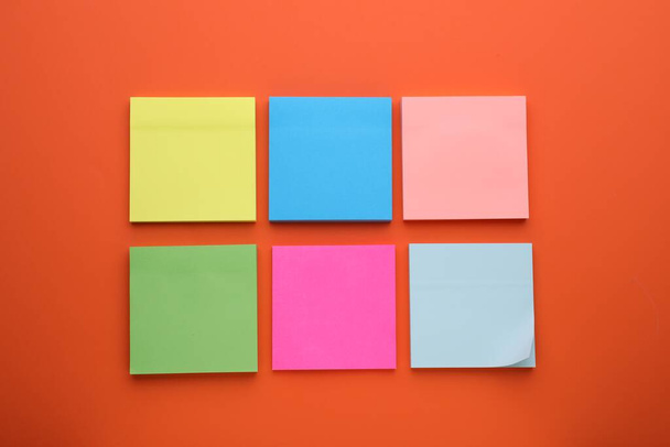Paper notes on orange background, flat lay - Foto, afbeelding