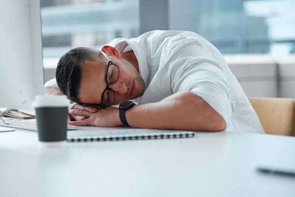 Τι κουραστική μέρα. Ένας νεαρός άνδρας επιχειρηματίας που δουλεύει σε τηλεφωνικό κέντρο και κοιμάται. - Φωτογραφία, εικόνα