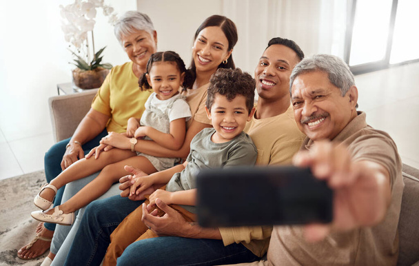 Telefonieren, Selfie und glückliche Familie auf einem Sofa mit Menschen, die sich entspannen, lächeln und sich in einem Wohnzimmer verbinden. Kinder, Eltern und Großeltern lächeln für ein Foto, während sie die Zeit auf der Couch zu Hause genießen. - Foto, Bild
