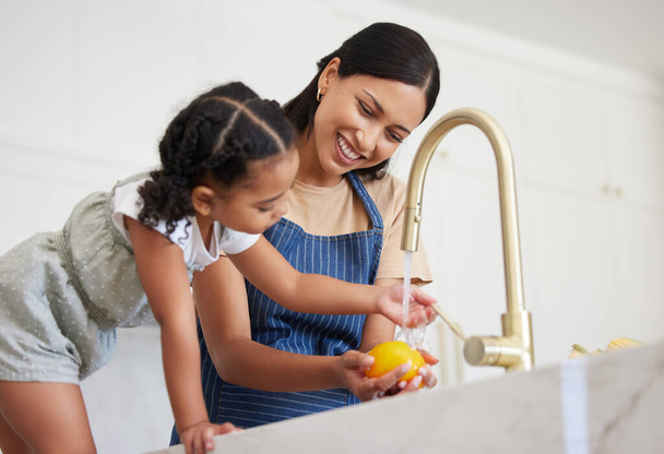 Takarítás, anya és gyermek mosás zöldség vízzel ebédre, táplálkozás vagy reggeli a konyhában a házuk. A gyermek vacsora előtt tanul meg főzni az anyjával.. - Fotó, kép