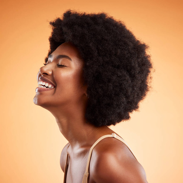 Beauty, black woman and laughing wellness, skincare and natural makeup, aesthetic glowing skin and clean cosmetics on orange studio background. Smile, happy and young model face, afro hair and funny. - Photo, Image
