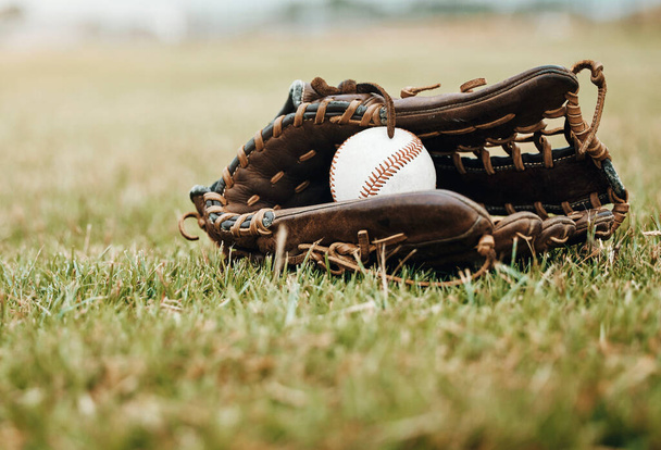 Baseball, sport and ball with glove on a grass pitch or field outdoor for a competitive game or match. Fitness, sports gear and skill with equipment on the ground for training, practice and game. - Foto, afbeelding