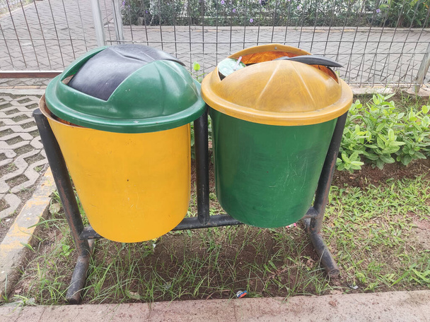 Karawang, Indonésie, 24. října 2022: Odpadkové koše v pěších zónách jsou obvykle zelené a žluté pro odlišení druhu odpadu - Fotografie, Obrázek