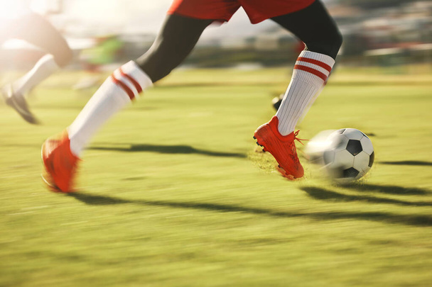 Fußball, Sport und Laufen mit den Schuhen eines männlichen Athleten auf einem Rasenplatz oder Feld während eines Spiels. Fußball, Fitness und Training mit einem männlichen Spieler, der während eines Spiels oder Cardio-Workouts dribbelt. - Foto, Bild