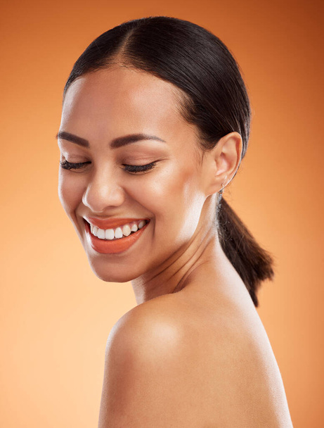 Woman, happy and beauty for skincare, health and wellness with cosmetic, perfect and smooth face. Model, smile and healthy for makeup, cosmetics and dermatology on skin with orange studio background. - Valokuva, kuva