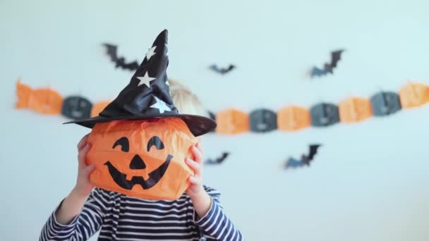 4k. Halloweeni gyerek otthon. Gyermek gazdaság és tánc egy boldog fej Gyermek készen áll a trükk vagy kezelni ünnep. Hagyományok, ünnepek, táj koncepció. - Felvétel, videó