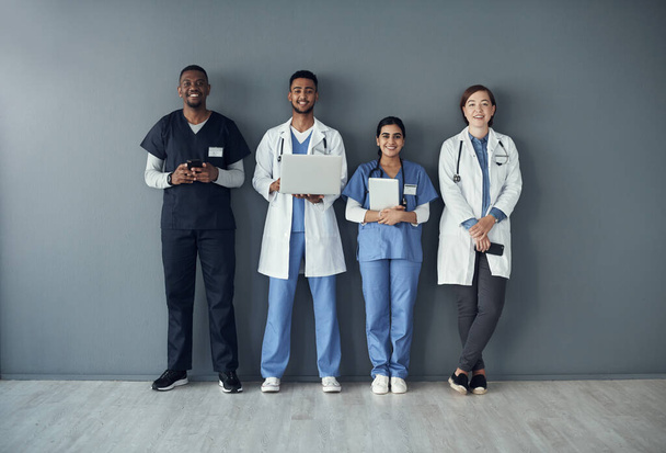 Laughter is the best medicine. a group of doctors standing against a grey background at work - Photo, image