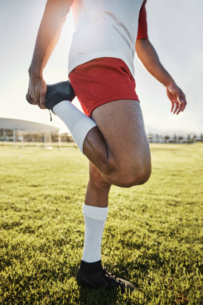 Exercise, man and athlete doing stretching, prepare for training and practice for soccer game with workout in sportswear on field. Football, wellness and healthy male ready match, fitness and warm up. - Foto, Imagen