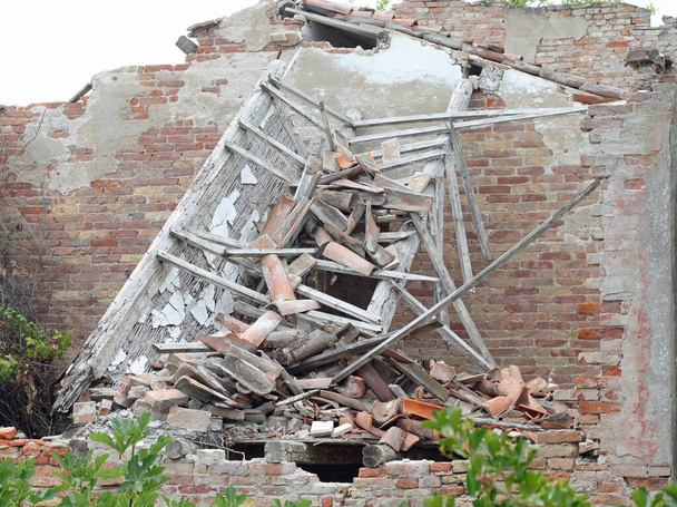 руїни будинку знищені після землетрусу цеглою та черепицею на даху
 - Фото, зображення