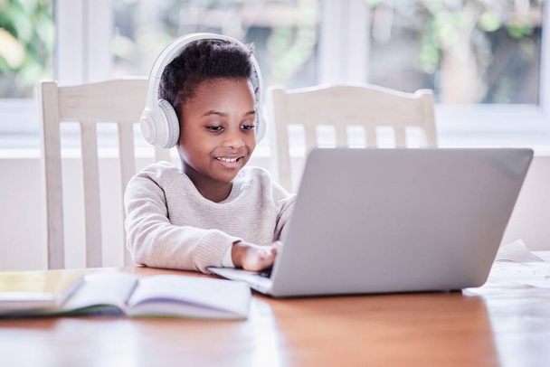 Löffelfütterung lehrt uns auf lange Sicht nichts. ein kleiner Junge macht seine Hausaufgaben auf einem Laptop zu Hause - Foto, Bild