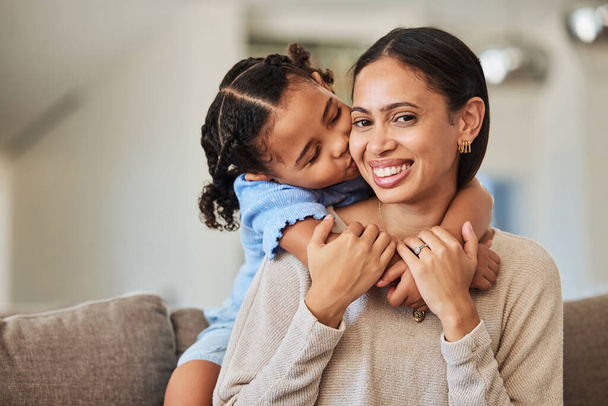 Black woman, smile and girl kiss cheek on sofa with love, bonding and happiness in home living room. Happy, mom and daughter care, together and portrait on mothers day in house for hug on couch. - 写真・画像