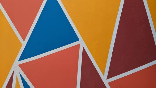 Colorful wall wallpaper with irregular triangular motifs. - Photo, image