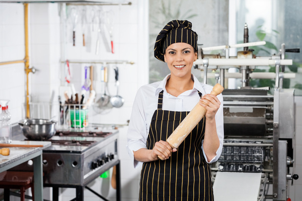 Happy Female Chef Holding Rolling Pin In Kitchen - Photo, image