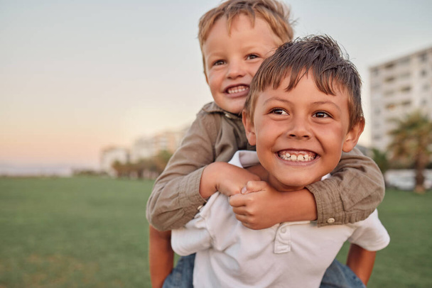 Счастливый, улыбчивый и с портретом братьев, играющих вместе в парке на отдыхе. Счастье, возбуждение и связь детей на природе во время летнего отдыха в Австралии - Фото, изображение