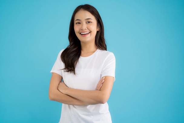 Schöne asiatische Frau steht dabei verschiedene Posen auf einem blauen Hintergrund glückliches Lächeln fühlen sich entspannt und Spaß. - Foto, Bild