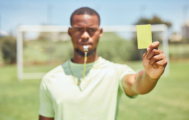 Piłka nożna, sędzia i żółta kartka z czarnym człowiekiem dając ostrożność graczowi podczas gry na świeżym powietrzu. Piłka nożna, fitness i ćwiczenia z młodym mężczyzną rezerwującym sportowca podczas meczu na zewnątrz. - Zdjęcie, obraz