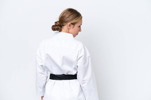 Nuori valkoihoinen nainen eristyksissä valkoisella taustalla tekemässä karatea takaasennossa - Valokuva, kuva