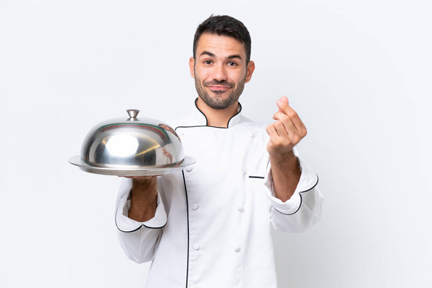Молодий шеф-кухар з підносом ізольований на білому тлі заробляє жест грошей
 - Фото, зображення