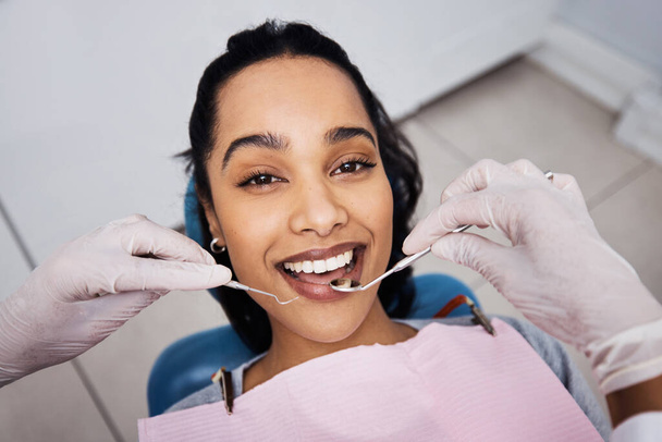 Der Gang zum Zahnarzt hat sich noch nie so gut angefühlt. eine junge Frau, die zahnärztliche Arbeiten an ihren Zähnen durchführt - Foto, Bild