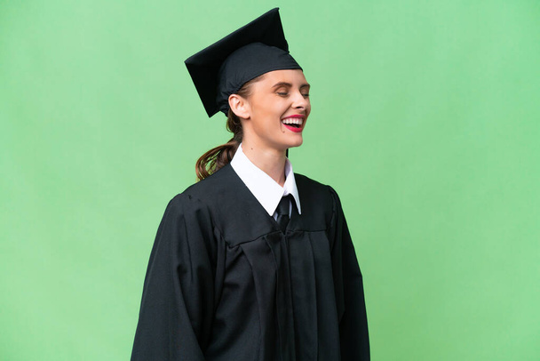 Молода випускниця університету кавказька жінка над ізольованим фоном сміється на бічній позиції
 - Фото, зображення